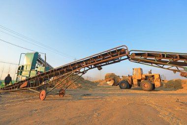 LUANNAN COUNTY, China - January 4, 2022: farmers operate machinery for rice straw briquetting, North Chin clipart