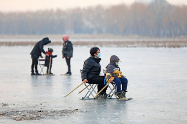 LUANNAN COUNTY, Çin - 8 Ocak 2022: turistler Kuzey Çin 'deki donmuş nehirde kayıyorlar