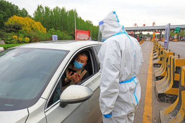 LUANNAN COUNTY, Çin - 27 Nisan 2022: Otoyol ihracat personeli sürücünün seyahat kodunu kontrol ediyor, Kuzey Çin
