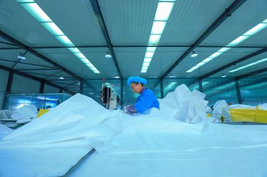 LUANNAN COUNTY, Çin - 12 Ocak 2022: İşçiler Kuzey Çin 'deki atölyede plastik fiber ürünler dikiyorlar