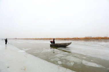 LUANNAN COUNTY, Çin - 21 Ocak 2022: İşçiler buzu suyun üzerine itmek için tekneleri kullanır, Kuzey Çene