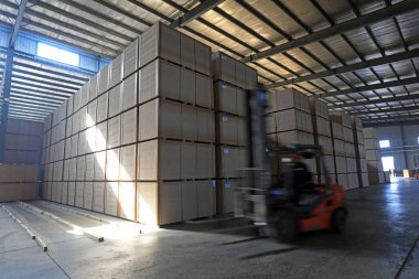 LUANNAN COUNTY, Çin - 26 Şubat 2022: İşçiler forkliftleri Kuzey Çin 'deki fabrikada yoğunluk tahtası ürünlerini taşımak için kullanıyorlar