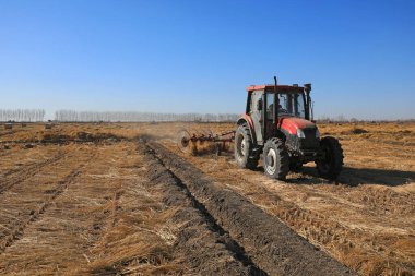 LUANNAN COUNTY, Çin - 1 Mart 2022: Çiftçiler tarlada saman toplamak için bir disk tırmığı kullanıyorlar, Kuzey Çin