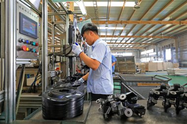 LUANNAN COUNTY, Çin - 15 Eylül 2021: İşçiler Kuzey Çin 'deki otomobil fren sisteminin üretim hattı üzerinde sıkı çalışıyorlar