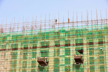 LUANNAN COUNTY, Çin - 15 Kasım 2021: inşaat işçileri Kuzey Çin 'de bir inşaat sahasında yapı iskelesi inşa ediyorlar