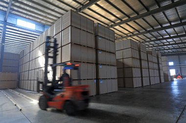 LUANNAN COUNTY, Çin - 26 Şubat 2022: İşçiler forkliftleri Kuzey Çin 'deki fabrikada yoğunluk tahtası ürünlerini taşımak için kullanıyorlar