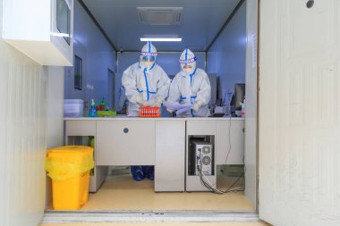 LUANNAN COUNTY, Çin - 22 Mart 2022: Tıbbi personel Kuzey Çin 'deki bir test merkezinde nükleik asit test örneklerini sayıyor