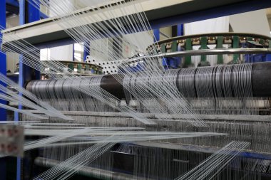 Plastik örgü üretim hattının mekanik ekipmanları bir fabrikada çalışıyor.