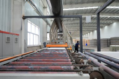 İşçiler, Kuzey Çin 'deki kalsiyum silikat üretim hattında dağıtıcıyı çalıştırıyor.