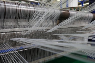 Plastik örgü üretim hattının mekanik ekipmanları bir fabrikada çalışıyor.