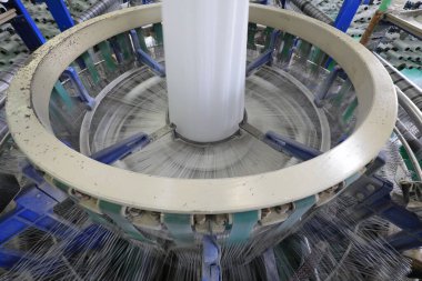 Plastik örgü üretim hattının mekanik ekipmanları bir fabrikada çalışıyor.