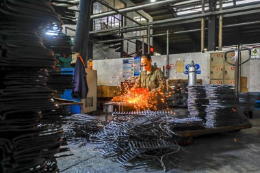 LUANNAN COUNTY, Çin - 24 Eylül 2021: işçiler yoğun bir kaynak üretim hattı üzerinde çalışıyor Kuzey Çin 'deki bir donanım araç imalat şirketinde