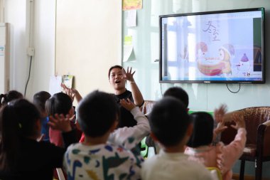 Tangshan, Çin - 21 Aralık 2021: Anaokulu çocukları öğretmenin rehberliğinde şarkı söylüyorlar, Kuzey Çin