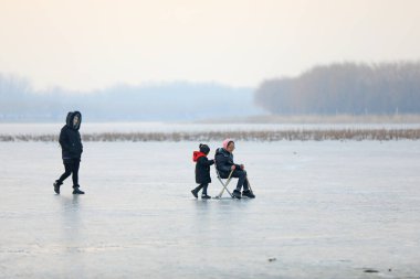 LUANNAN COUNTY, Çin - 8 Ocak 2022: turistler Kuzey Çin 'deki donmuş nehirde kayıyorlar