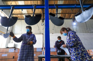 LUANNAN COUNTY, Çin - 5 Nisan 2022: işçiler Kuzey Çin 'deki bir nalbur imalat şirketinde çelik kürek üretim hattı üzerinde sıkı çalışıyorlar.