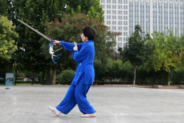 LUANNAN COUNTY, Çin - 12 Eylül 2021: insanlar parkta Tai Chi kılıcı kullanırlar, Kuzey Çin