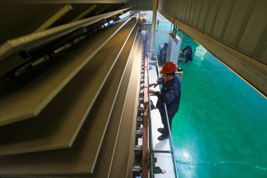 LUANNAN COUNTY, Çin - 26 Şubat 2022: İşçiler Kuzey Çin 'deki fabrikadaki parçacık üretim hattı üzerinde sıkı çalışıyorlar