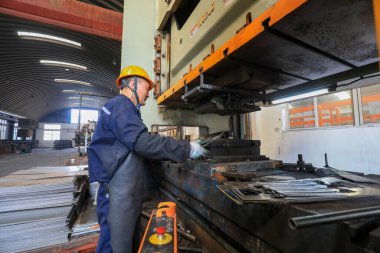 LUANNAN COUNTY, China - April 5, 2022: workers work hard on the steel shovel production line in a hardware tool manufacturing enterprise, North China clipart