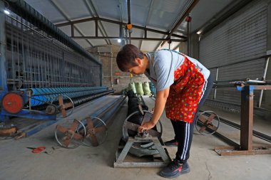 LUANNAN COUNTY, Çin - 30 Ağustos 2021: İşçiler Kuzey Çin 'deki bir işleme tesisinde ağ örme ekipmanları taşıyorlar