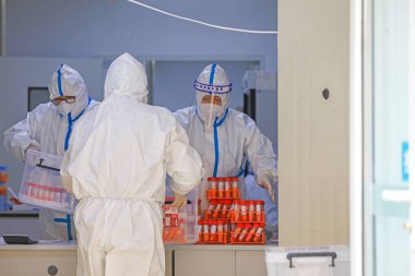 LUANNAN COUNTY, Çin - 29 Mart 2022: Tıp çalışanları Kuzey Çin 'deki bir test üssünde COVID-19 nükleik asit tespit örnekleri alıyorlar