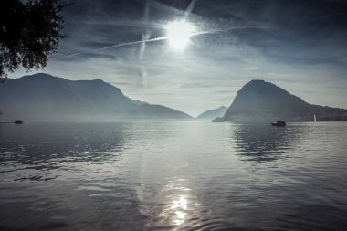 Lugano Gölü 'nde gündoğumu, San Salvatore tepesi arka planı, İsviçre. Dinginlik ve rahatlama kavramı