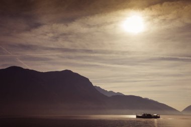 Dramatik bir gündoğumu sırasında gölde tekne gezintisi. Lugano, Ticino, İsviçre