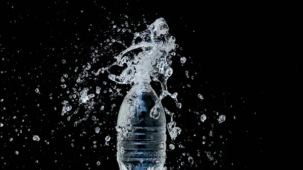 Abstract water jet crashes on a black background from a plastic bottle