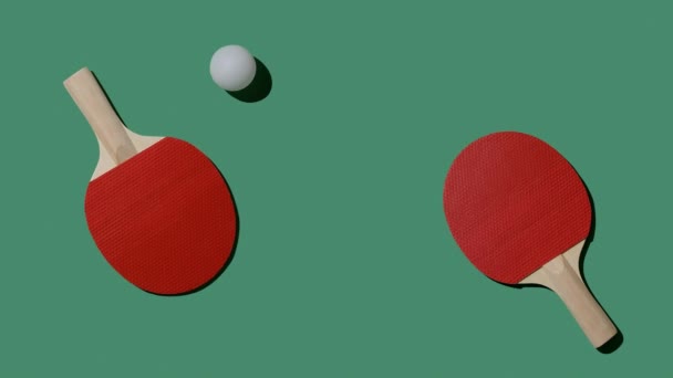 Κόκκινες Ρακέτες Και Μια Λευκή Μπάλα Κινούνται Ένα Πράσινο Τραπέζι — Αρχείο Βίντεο