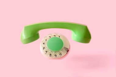 Pembe arka planda, cihazın olmadığı eski bir telefonun telefon ve diski. Minimum kaybolan nesne kavramı. Yüksek kalite fotoğraf