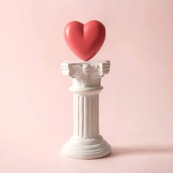 An antique Roman column with the symbol of the romantic heart. A minimal playful concept about a couples love and relationship. High quality photo