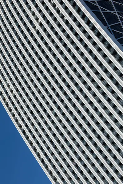在明亮的蓝天下 一幅简约的照片映衬着一座外型重复的现代建筑的一部分 图库照片