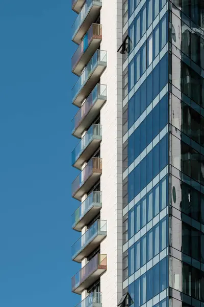 一座由玻璃 钢铁和混凝土与蓝天相映成趣的现代化住宅建筑的细节 图库图片