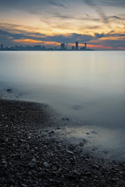 Günbatımının renkli gökyüzüne karşı modern mimari silueti ile Batumi şehrinin ufuk çizgisi.