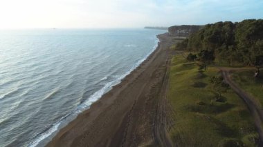 Gürcistan 'da sakin bir gökyüzünün altında yemyeşil bir ormanlık ile çevrili kumlu bir deniz ile buluşmanın yüksek perspektifi
