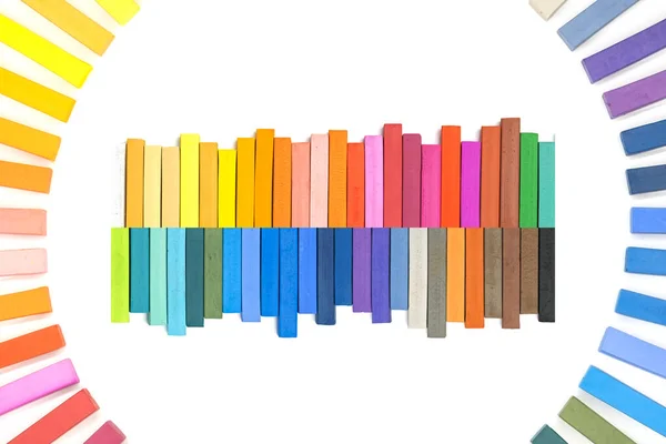 円の中に多色のパステルカラーのチョークで虹色のスペクトルとして配置されたハードチョークのパステル — ストック写真