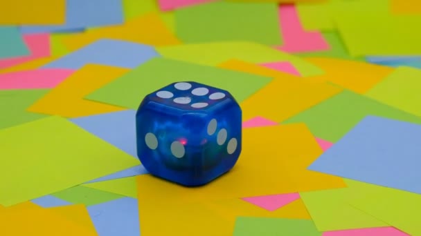 Blue Plastic Dice Multicolored Paper Sticky Notes Background Slow Motion — Video Stock
