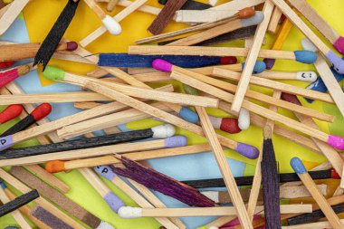 matchsticks of various shapes and colors with multicolored paper sticky notes on background