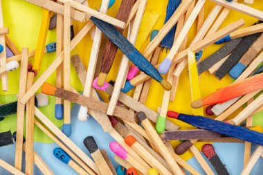 matchsticks of various shapes and colors with multicolored paper sticky notes on background