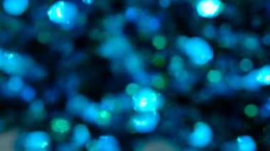 Yavaş çekimde mavi parıltılı arka plan. Gerçek mavi parçacıklarla güzel bir geçiş. Siyah zemin üzerinde rüzgarda uçan, alanın derinliğiyle çekilen.