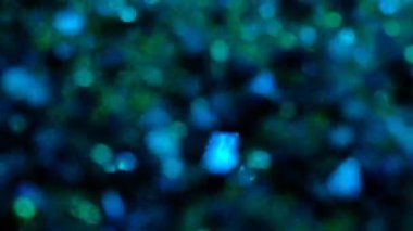 Altın parıltılı arka plan. Gerçek altın parçacıkları ile güzel bir geçiş. Siyah zemin üzerinde rüzgarda uçan, alanın derinliğiyle çekilen.