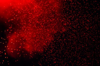 Siyah arkaplana düşen parlak kırmızı konfeti