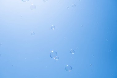 Mavi gökyüzünde sabun köpükleri. Havada güzel yanardöner köpük topları var.