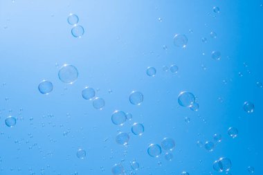 Mavi gökyüzünde sabun köpükleri. Havada güzel yanardöner köpük topları var.