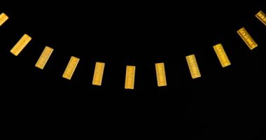 Siyah arkaplan ile dönen tablo üzerinde altın çubuklar