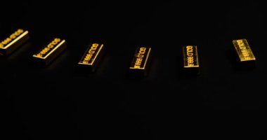 Siyah arkaplan ile dönen tablo üzerinde altın çubuklar