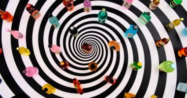 Bir çok çeşit minyatür reçine şişeleri sonsuz dönen spiral dönen masa arkaplanında içerler.
