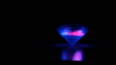 Mavi ve kırmızı ışıklar siyah bir masanın üzerinde dönüyor.