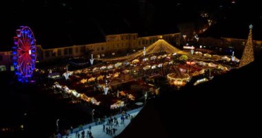 Sibiu, Romanya - 09 Aralık 2023. Romanya 'nın Transilvanya kentinin tarihi merkezi Sibiu' daki Geleneksel Noel pazarının panoramik gece manzarası.
