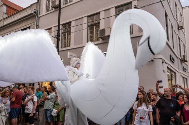 Sibiu City, Romanya - 01 Temmuz 2022. Romanya 'nın Sibiu kentinde düzenlenen Uluslararası Tiyatro Festivali sırasında kuğu kostümlü sanatçıların yer aldığı sokak geçidi.