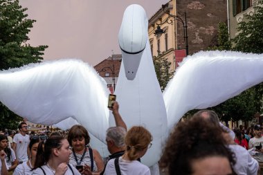 Sibiu City, Romanya - 01 Temmuz 2022. Romanya 'nın Sibiu kentinde düzenlenen Uluslararası Tiyatro Festivali sırasında kuğu kostümlü sanatçıların yer aldığı sokak geçidi.